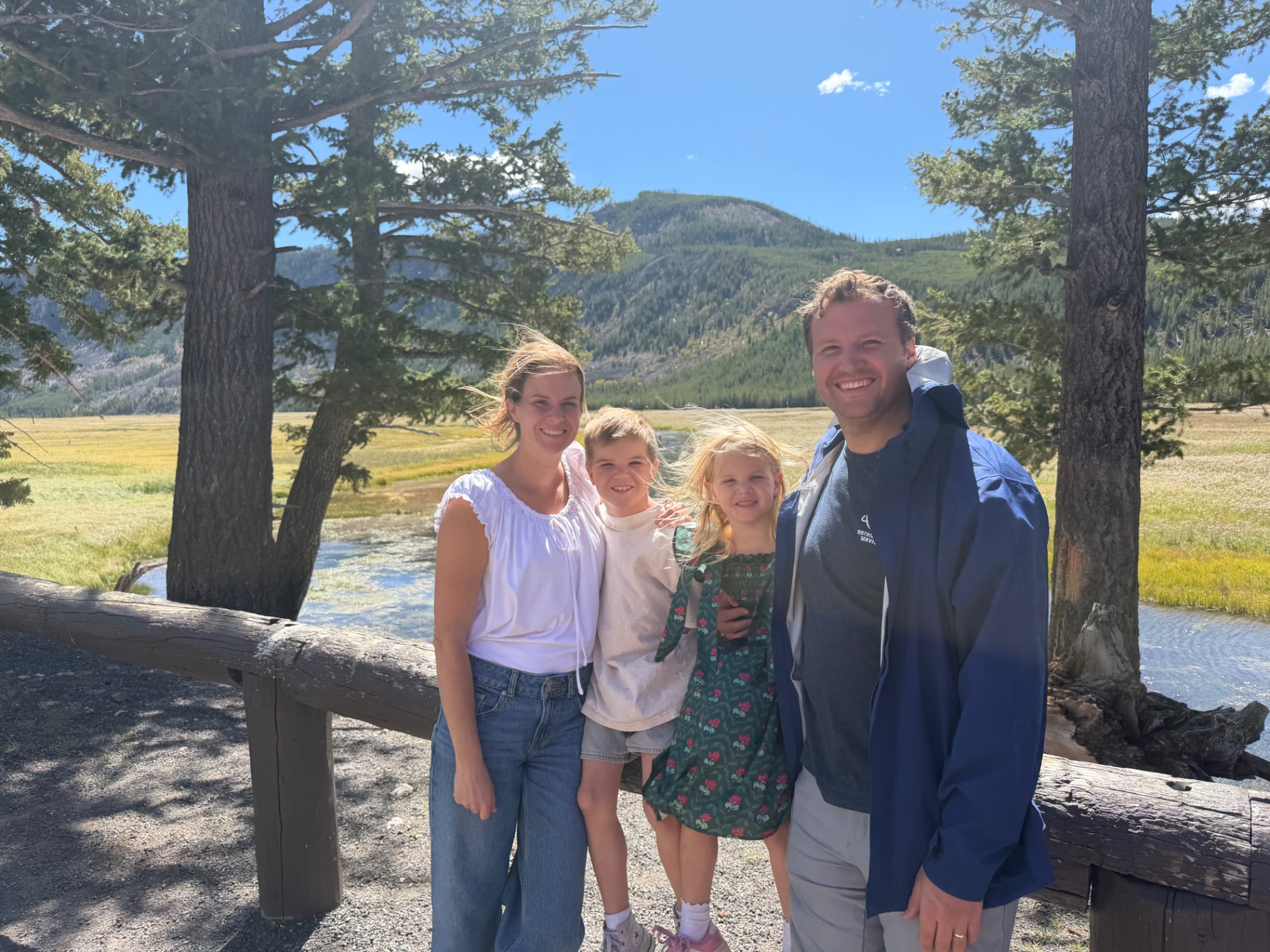 Ashley with her husband and two kids on a sunny trail in Yellowstone