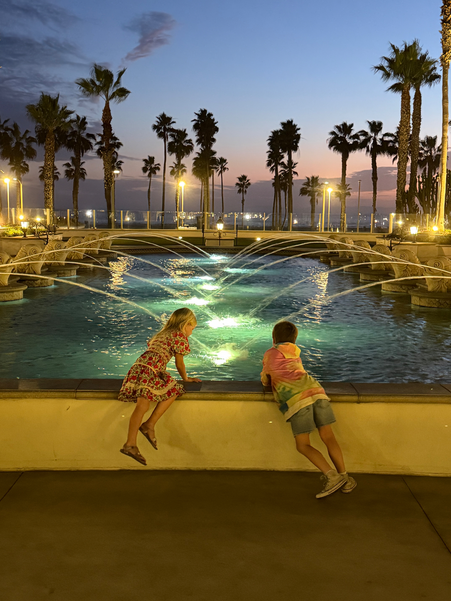 My kids at the resort fountain at sunset